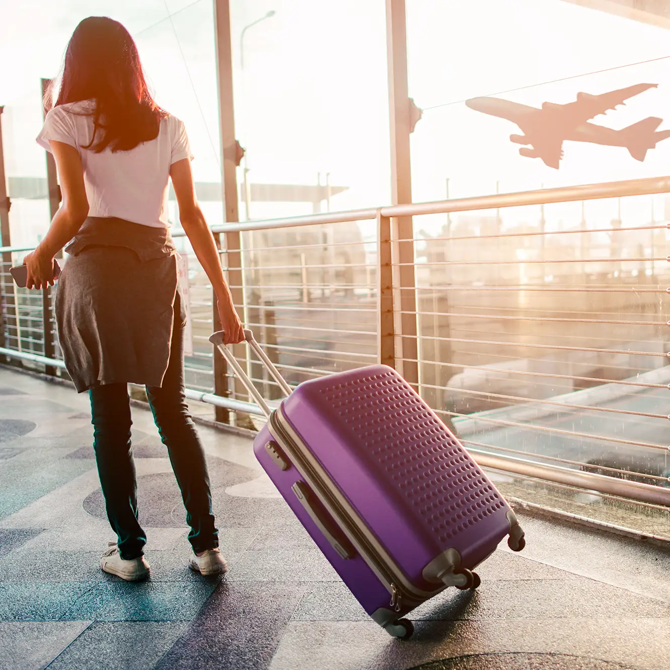 Junge Frau mit Koffer am Flughafen