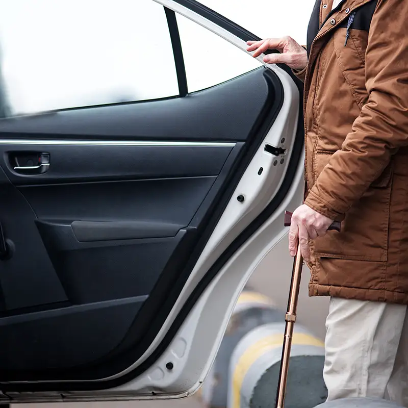 Mann mit Gehstock steigt in Taxi